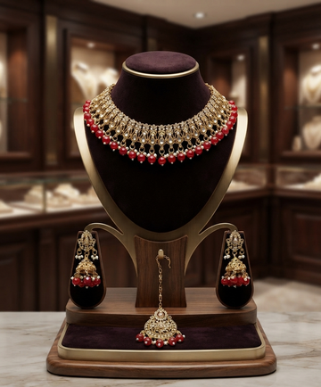 Gold Kundan Choker Set With Red Beaded Accents.