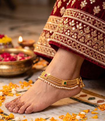 Exquisite multi-strand gold anklet with ruby, emerald, and pearl accents.