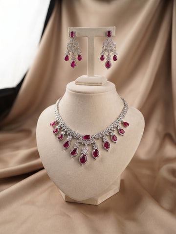 Elegant rhodium plated contemporary necklace and earring set with ruby crystals featuring dazzling CZ crystals.