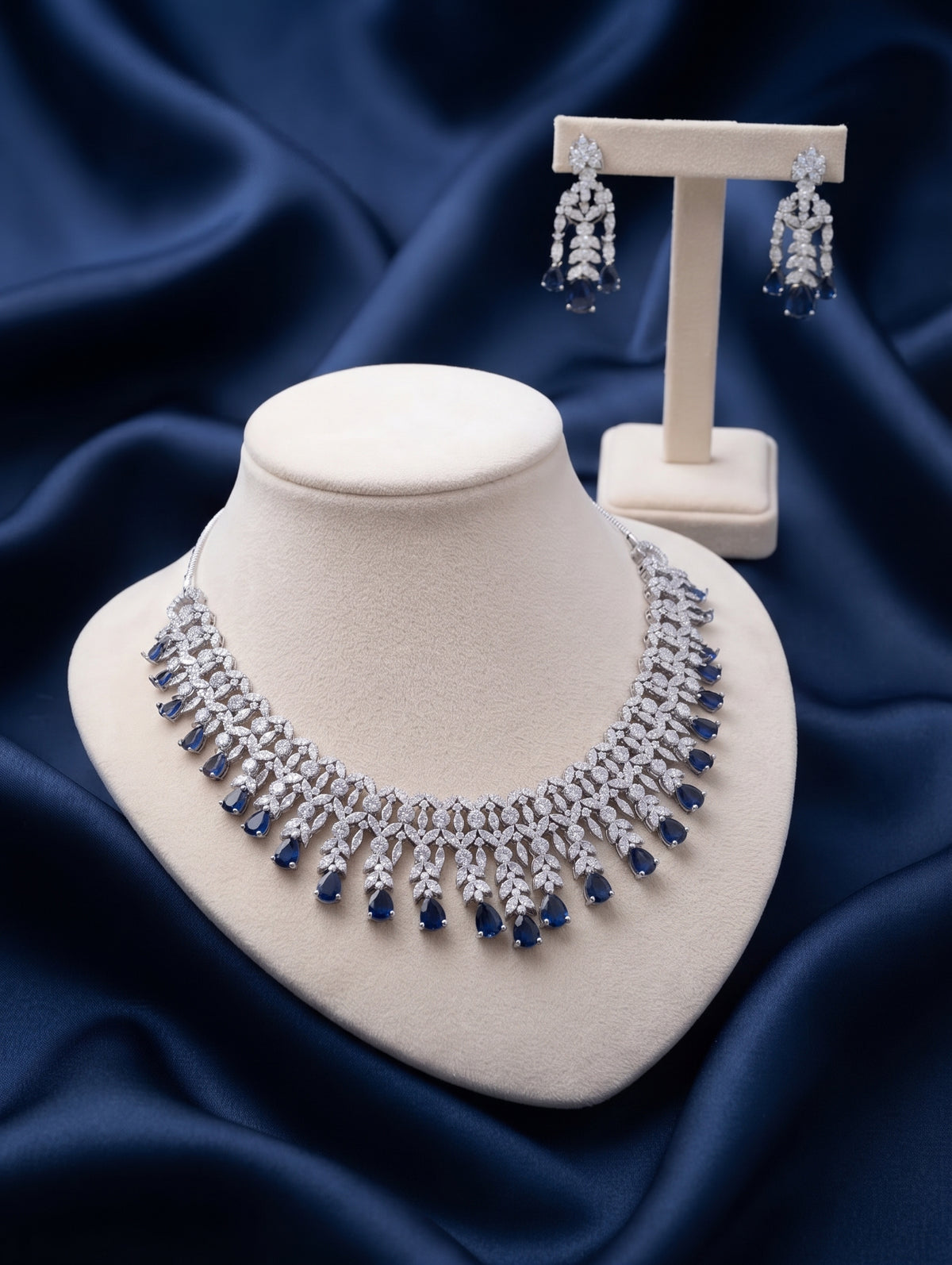 Elegant rhodium plated contemporary necklace and earring set with dark blue crystals featuring dazzling CZ crystals.