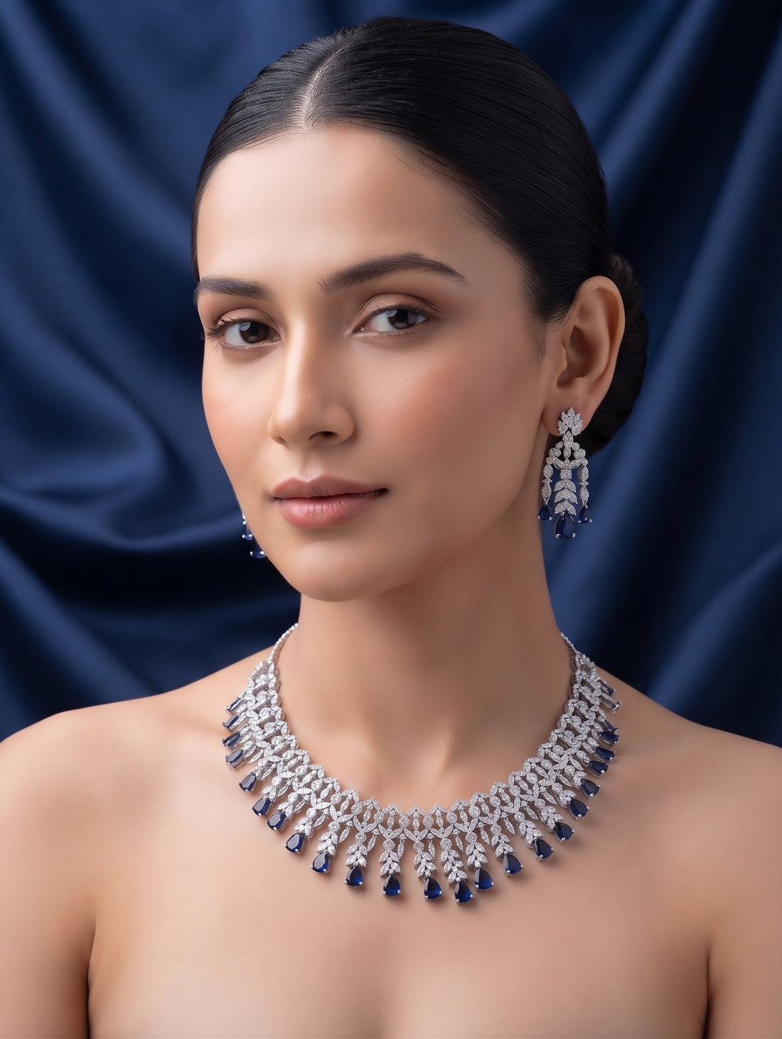 Elegant rhodium plated contemporary necklace and earring set with dark blue crystals featuring dazzling CZ crystals.