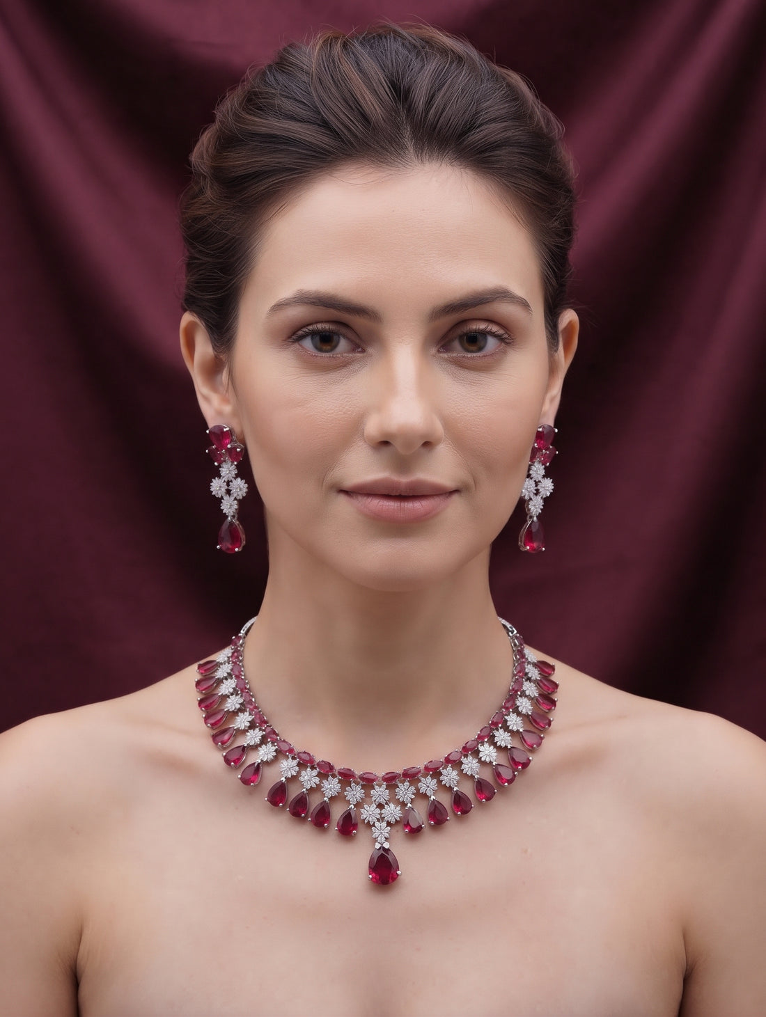 Stylish rhodium plated necklace and earring set adorned with sparkling maroon CZ crystals.