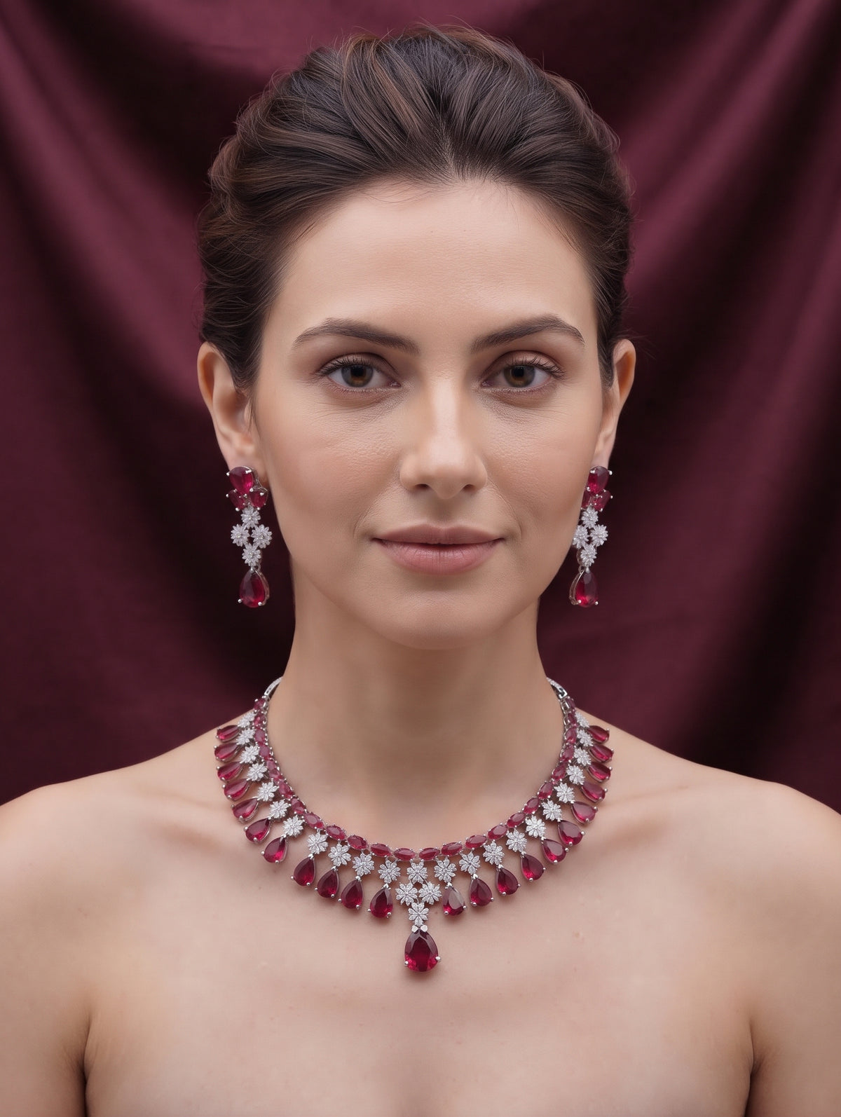 Stylish rhodium plated necklace and earring set adorned with sparkling maroon CZ crystals.