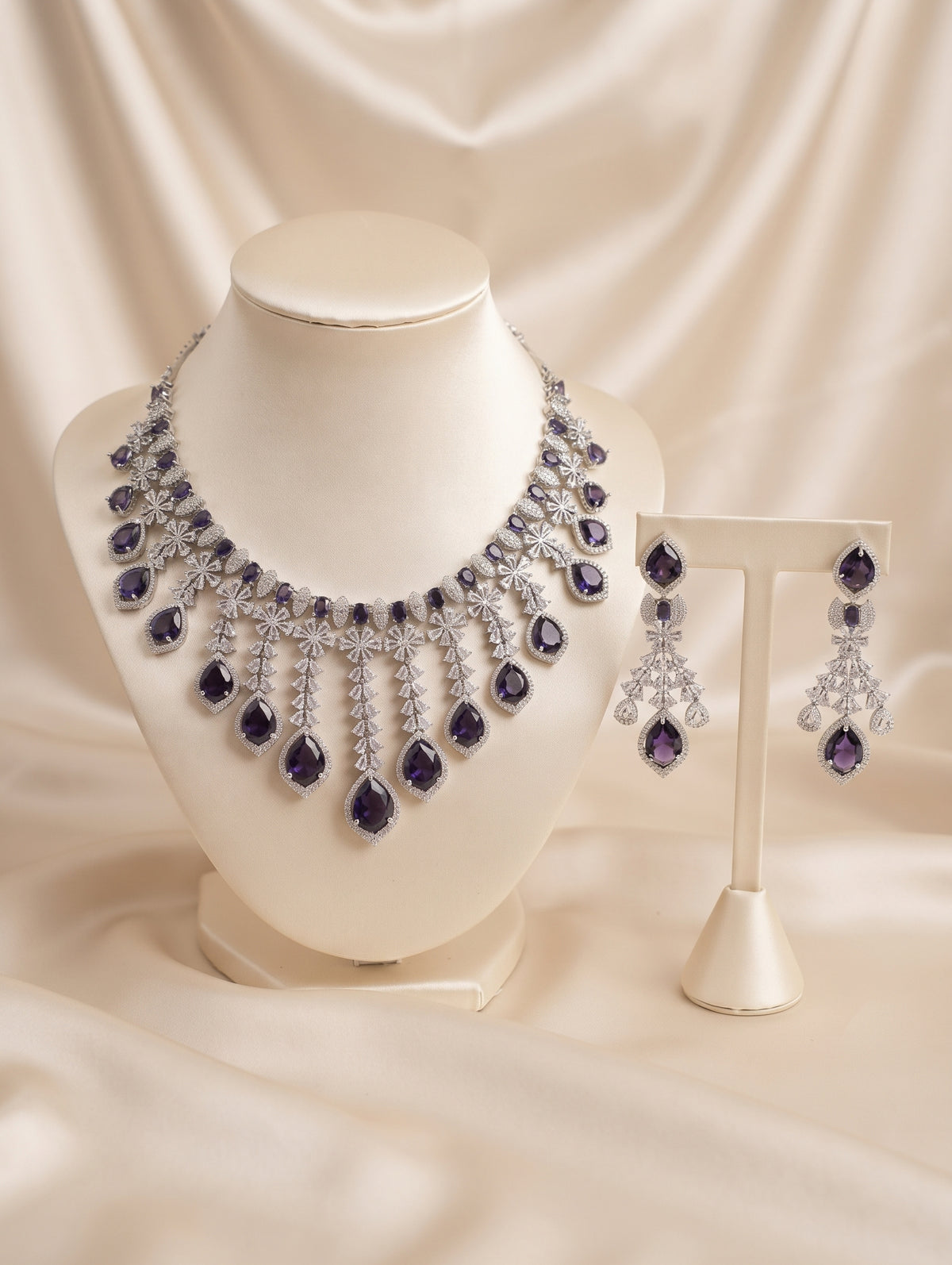 Stylish rhodium plated necklace and earring set adorned with sparkling purple CZ crystals.