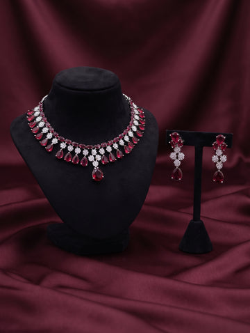 Stylish rhodium plated necklace and earring set adorned with sparkling maroon CZ crystals.
